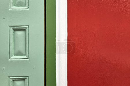 Foto de Mínimo rojo pintura hormigón pared y madera verde puerta textura para fondo. - Imagen libre de derechos