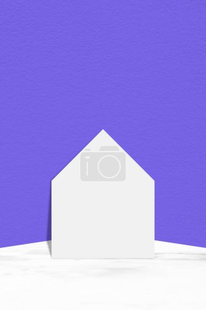 Foto de Casa de corte de papel blanco en mesa de mármol con fondo de pared de hormigón azul claro, adecuado para fondo de presentación de productos, pantalla y simulacro para redes sociales o teléfono móvil. - Imagen libre de derechos