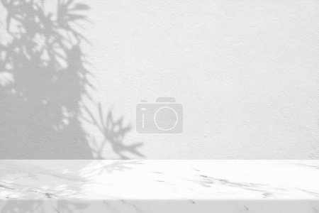 Foto de Mesa de mármol mínima con sombra de hojas en fondo de textura de pared de estuco, adecuada para fondo de presentación de productos, pantalla y simulacro. - Imagen libre de derechos