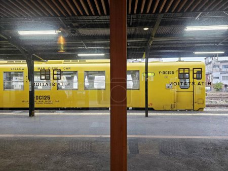 Téléchargez les photos : HITA, JAPON - 12 NOVEMBRE 2023 : Décors de la voiture diesel jaune One Man par vitre à la gare de Hita où se trouve une gare sur la ligne principale Kyudai exploitée par JR Kyushu à Hita. - en image libre de droit