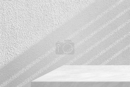 Foto de Mesa de hormigón Loft con fondo de textura de pared de estuco blanco con haz de luz y sombra, adecuada para fondo de presentación de productos, pantalla y simulacro. - Imagen libre de derechos