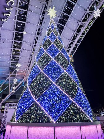 Foto de FUKUOKA, JAPÓN - 13 de noviembre de 2023: Gran árbol de Navidad frente a la estación de Hakata. La estación de Hakata es una estación ferroviaria importante en Hakata ku, Fukuoka, Japón.. - Imagen libre de derechos