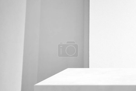 Téléchargez les photos : Coin de table en marbre blanc minimal avec fond mural en béton éclairé, adapté à la présentation du produit, à l'affichage et au maquillage. - en image libre de droit