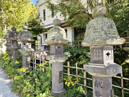 Foto de FUKUOKA, JAPÓN - 14 DE NOVIEMBRE DE 2023: Faroles de piedra en el templo de Nanzoin, donde se encuentra el monumento de Sasaguri, Fukuoka, Japón. - Imagen libre de derechos
