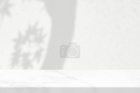 Foto de Mesa de mármol blanco con sombra de árbol de arce en fondo de textura de pared de hormigón, adecuado para fondo de presentación de productos, pantalla y simulacro. - Imagen libre de derechos