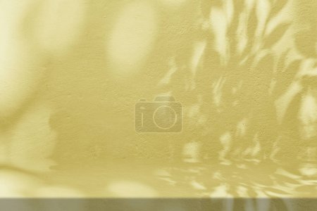 Foto de Mesa de estuco dorado con sombra de naturaleza sobre fondo de textura de pared de hormigón, adecuada para fondo de presentación de productos cosméticos, pantalla y simulacro. - Imagen libre de derechos