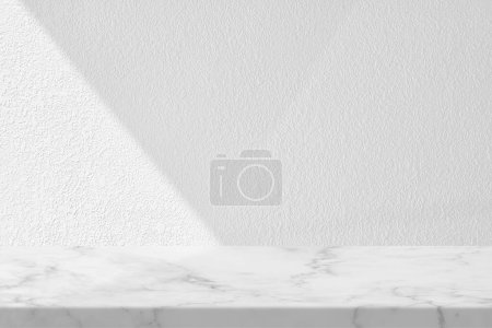 Téléchargez les photos : Table en marbre avec fond de texture murale en stuc blanc avec faisceau de lumière et ombre, adaptée à la présentation du produit, à l'affichage et au maquillage. - en image libre de droit