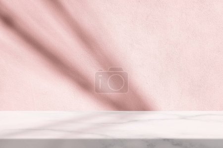 Foto de Mesa de mármol con fondo de textura de pared de estuco blanco con haz de luz y sombra de alambre en tono rosa, adecuado para el fondo de la presentación del producto, pantalla y simulacro. - Imagen libre de derechos