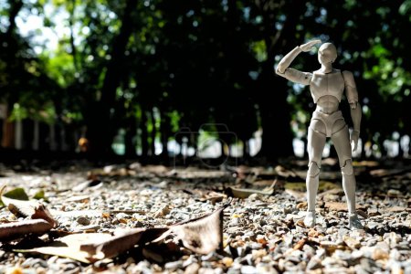 Photo for BANGKOK, THAILAND - NOVEMBER 23, 2017: Drawing figure standing in the park and raising his hand for shading from sunlight. - Royalty Free Image