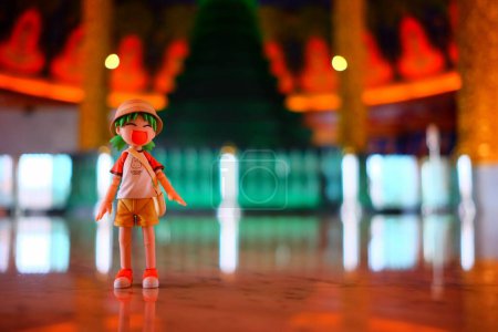 Foto de BANGKOK, TAILANDIA - 23 DE NOVIEMBRE DE 2017: Figura de anime miniatura de Yotsuba Koiwai viajando por el Templo Wat Paknam. Yotsuba Koiwai es famosa serie de comedia japonesa maga. - Imagen libre de derechos