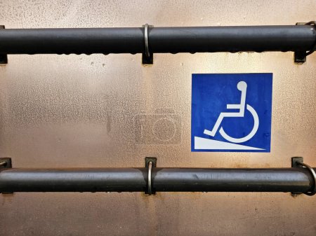 Foto de Señal de acceso a la rampa para discapacitados con pasamanos de metal en la estación de tranvía. - Imagen libre de derechos