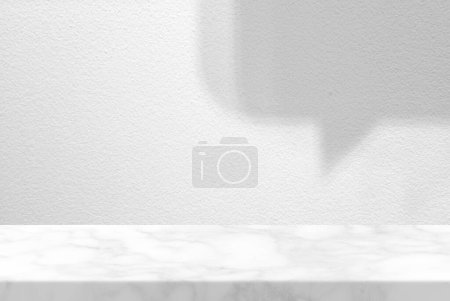 Téléchargez les photos : Table en marbre avec fond de texture murale en stuc blanc avec faisceau lumineux et ombre de texte à bulles, adaptée à la présentation du produit, à l'affichage et au maquillage. - en image libre de droit