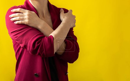 Foto de Embrace equity. Woman hug yourself dressed magenta jacket on yellow background. International womens day concept. Vivid colors, copy space - Imagen libre de derechos