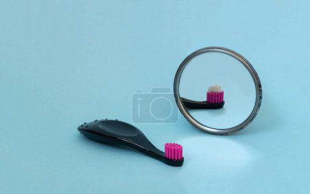 Téléchargez les photos : Kids toothbrush with toothpaste mirorr reflection. International day of dentist. Creative concept of daily morning routine. Copy space - en image libre de droit