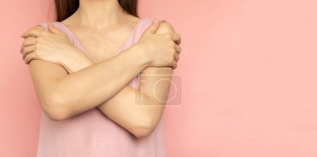 Embrace equity. Woman hug yourself dressed pastel pink dress on pink background. International womens day concept. Pastel colors, copy space