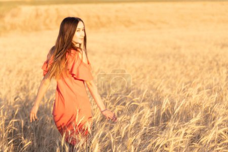 Photo for Young woman in the wheat field. Look back. Finding inner balance concept. Copy space. - Royalty Free Image