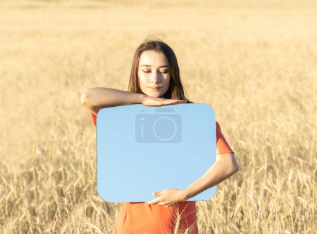 Photo for Young woman in the wheat field, holding mirror glass where reflected the blue sky. Meditation, mental health concept. Copy space - Royalty Free Image