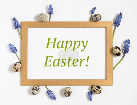Foto de Composición de Pascua con papel en blanco con texto Feliz Pascua, huevos de codorniz, flores frescas y marco dorado.Vista superior, puesta plana - Imagen libre de derechos
