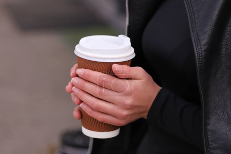 Photo for Cup with coffee in female hands, street photo, fast food concept - Royalty Free Image