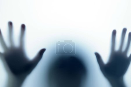 Téléchargez les photos : Ombre floue dans la lumière bleue devant la porte. Le concept de cauchemars, fantômes, horreur, paranormal - en image libre de droit