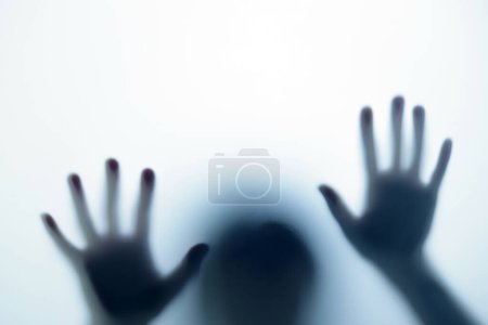 Téléchargez les photos : Ombre floue dans la lumière bleue devant la porte. Le concept de cauchemars, fantômes, horreur, paranormal - en image libre de droit