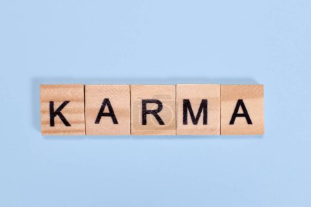 Téléchargez les photos : Karma mot de lettres en bois sur fond bleu - en image libre de droit
