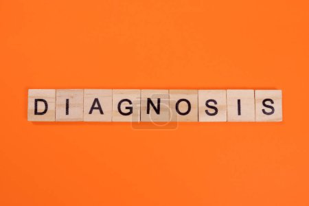 Foto de Palabra de diagnóstico hecha de letras de madera sobre fondo naranja - Imagen libre de derechos