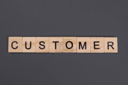 Customer word from wooden blocks on gray background