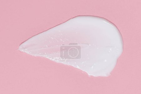 Téléchargez les photos : Crème visage ou corps étalée sur fond rose - en image libre de droit