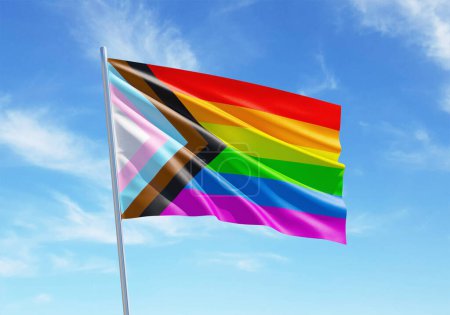 Progress Pride rainbow flag waving in a blue sky background for LGBTQIA+ Pride month, sexuality freedom, love diversity celebration and the fight for human rights in 3D illustration