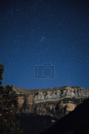 Photo for Ordesa National Park mountains at night with the sky full of stars. Ordesa y Monte Perdido National Park is in the heart of the Pyrenees and a protected natural areas in Europe - Royalty Free Image