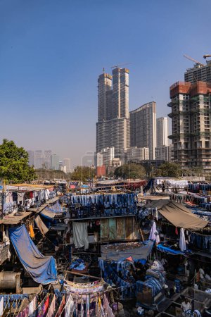 Foto de Incredible view of the Dhobi Ghat in Mumbai, the largest open-air laundry in the world. Impressive social contrast with skyline skyscrapers. - Imagen libre de derechos