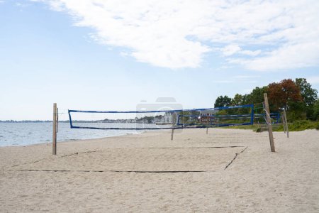 Photo for Empty beach with volleyball nets set up for playing. Houses along the shore in Connecticut - Royalty Free Image