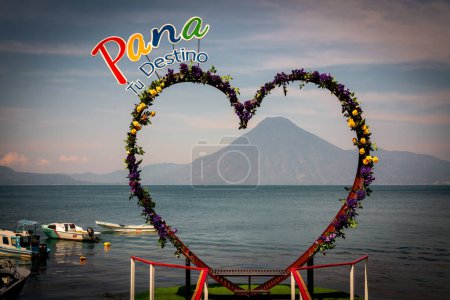 Photo for Heart shaped spot for photo taking with Pana your destination sign in lake atitlan and volcano in the distance in Panajachel, Guatemala - Royalty Free Image