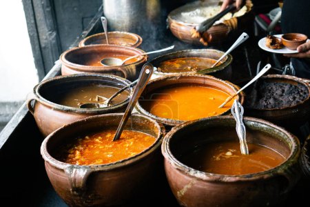 Foto de Variedad de comida tradicional guatemalteca local servida en grandes macetas rústicas de barro - Imagen libre de derechos