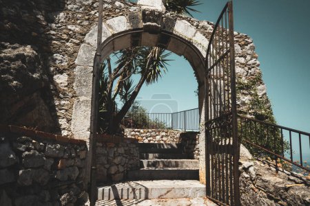 Foto de Antiguo muro de piedra envejecida vintage con puerta de apertura arqueada y escaleras arriba - Imagen libre de derechos