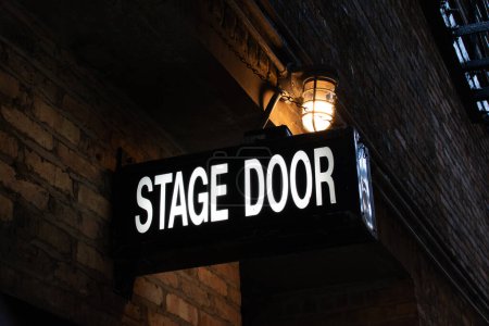 Photo for Vintage illuminated stage door sign in a dark and dingy back alley in the city of Chicago, Illinois, USA - Royalty Free Image