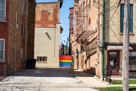 Antiguo escaparate y callejón con escalera pintada en colores arco iris. Woodstock, Illinois, EE.UU..