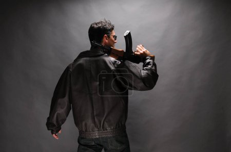 Photo for The sexy man is posing with a rifle in hand. - Royalty Free Image