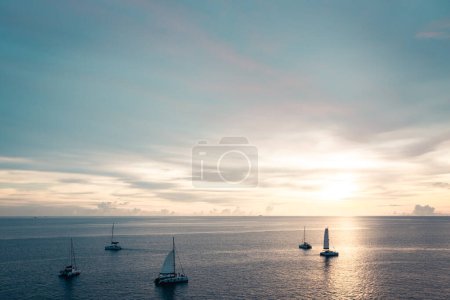 Foto de Atardecer dorado brilla sobre el mar con veleros - Imagen libre de derechos