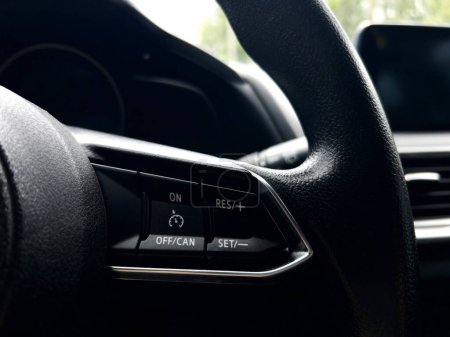 High-detail image capturing the texture and controls on a car steering wheel, emphasizing modern automotive design.
