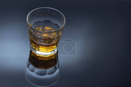 Photo for A glass of ice-free alcohol on a black glass table - Royalty Free Image