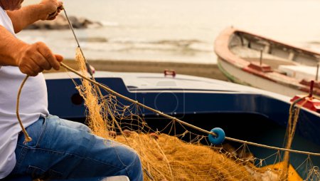 Foto de Palangre de pesca, redes de captura de peces, pescador corrige y prepara el material para trabajar en el Mar Mediterráneo. - Imagen libre de derechos