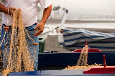 Téléchargez les photos : Malaga pêcheur avec des filets sur les mains sur les plages du bâton, se prépare pour la pêche - en image libre de droit