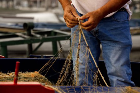 Téléchargez les photos : Malaga pêcheur avec des filets sur les mains sur les plages du bâton, se prépare pour la pêche - en image libre de droit