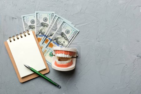 Photo for Flat lay composition with educational dental typodont model and money with notebook on colored table, top view. Expensive treatment. - Royalty Free Image