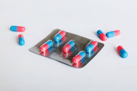 Foto de Medicine pills on a light background. Medicines and prescription pills flat lay background. Blue and pink medical tablets in blister. - Imagen libre de derechos