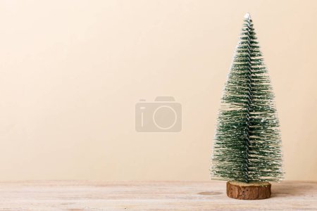 One small Christmas tree on colored background. new year decoration with copy space.