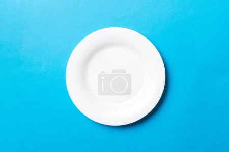 Vue du dessus de isolé de fond coloré plaque blanche ronde vide pour la nourriture. Plat vide avec espace pour votre design.