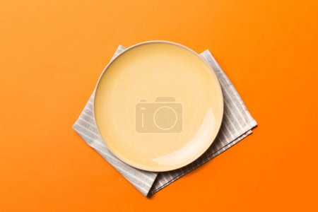 Photo for Top view on colored background empty round yellow plate on tablecloth for food. Empty dish on napkin with space for your design. - Royalty Free Image